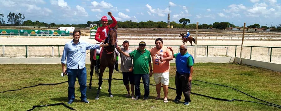 Premiação no gramado do Hipódromo do Aquiraz, com o jóquei montado e o grupo do vencedor
