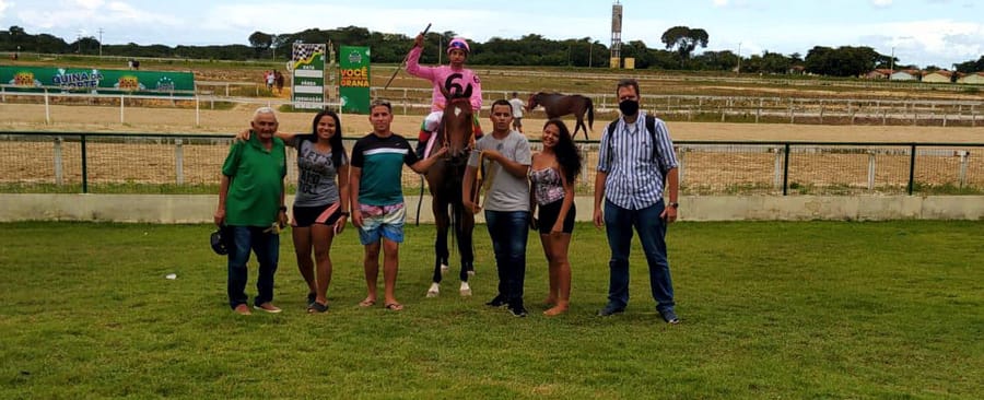 Grupo comemora com o cavalo vencedor no gramado do hipódromo