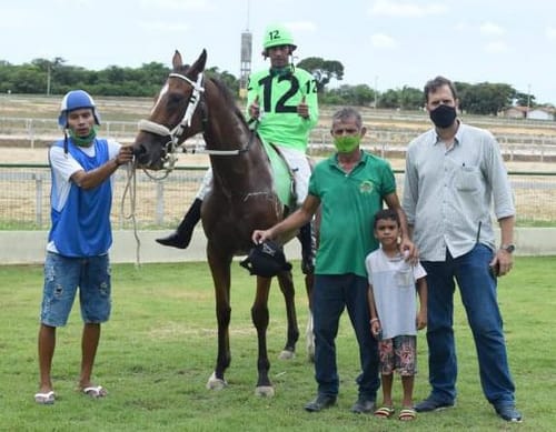 Vencedor com jóquei montado e família na foto de premiação